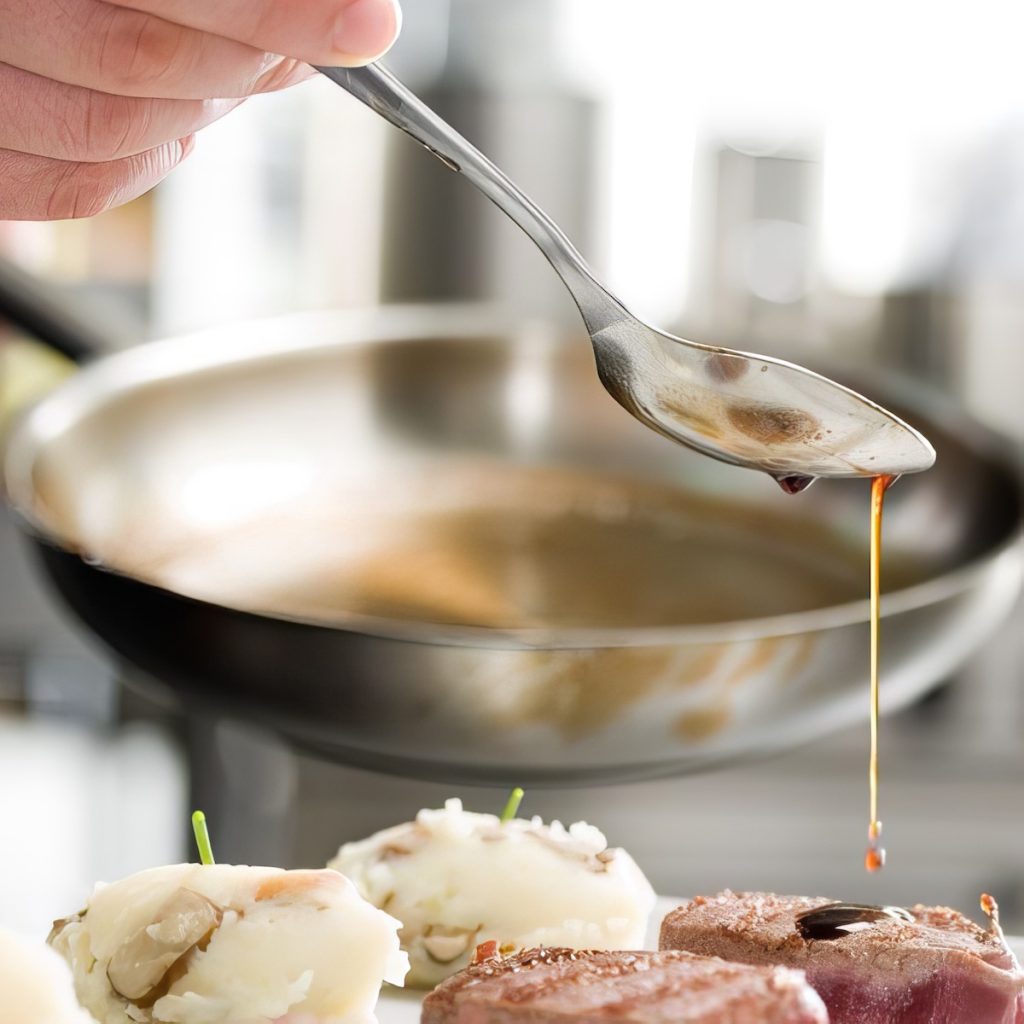 Chef applying sauce to plated dish