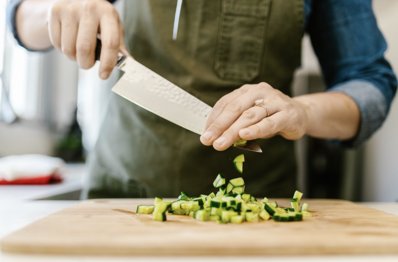 Chef hands expertly dicing cucumber with knife