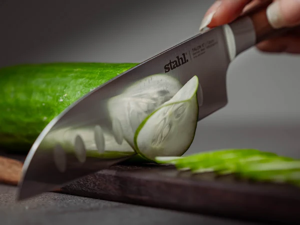 Hand slicing cucumber with chef knife