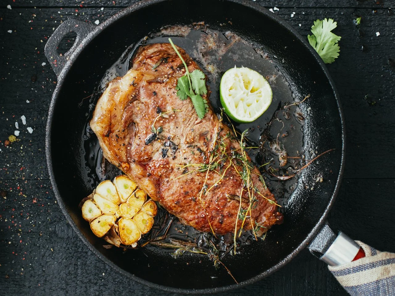 Perfectly seared steak in cast iron pan with herbs